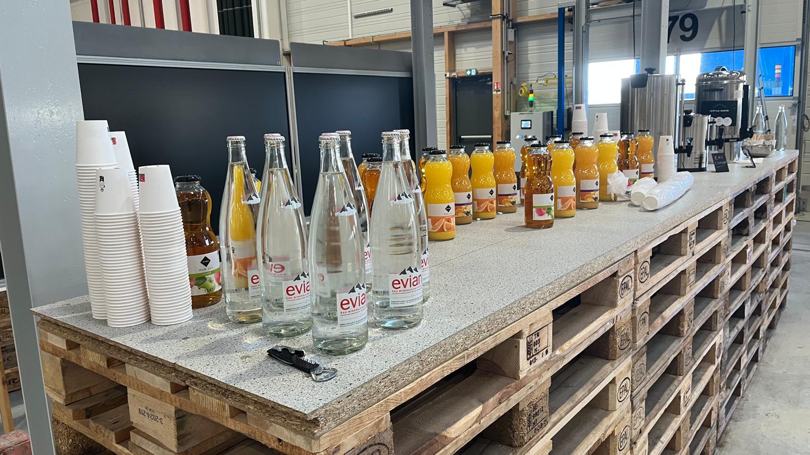 Point boissons installé pour un événement d'entreprise : eau, jus de fruits et café