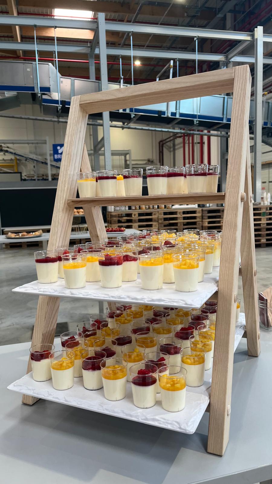 Verrines de panna cotta aux fruits rouges et à la mangue présentées sur un support en bois
