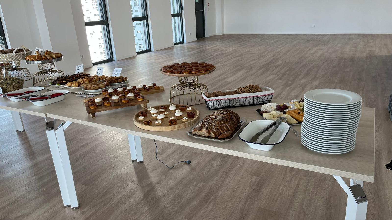 Table de buffet avec feuilletés, brochettes, mignardises, pains et fromages